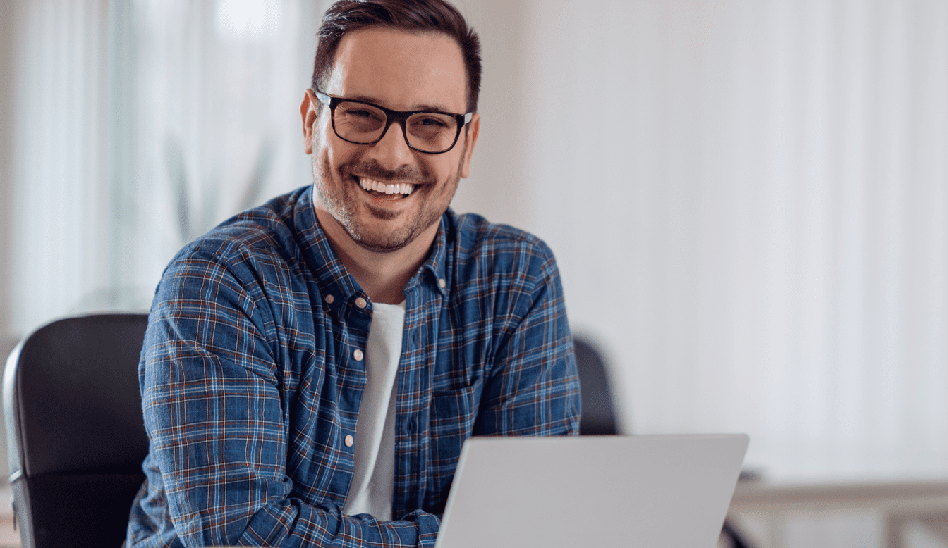 Ready to purchase your MILLPWRG2? left Section Image which have smiling person with glasses on in-front of laptop.
